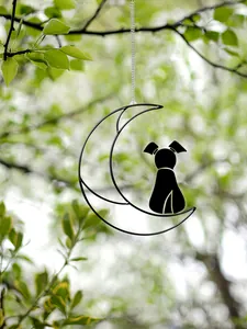 Detailed view of a black dog silhouette on a crescent moon hanging decoration for home