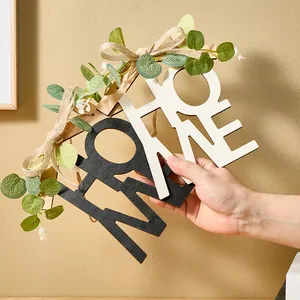 Primer plano de placa decorativa de madera 'HOME' con hojas artificiales y un lazo
