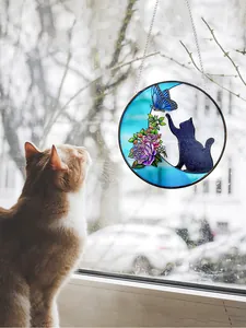 Stained glass suncatcher with black cat and butterfly design hanging as window decoration