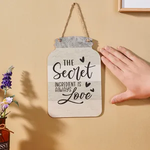 Detailansicht eines hölzernen Schilds in Glasform mit Love-Zitaten für die Küche