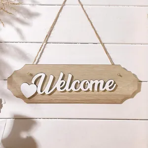 Detailed close-up of wooden welcome door hanging sign with heart on white wall