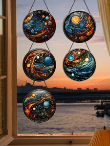Vue détaillée d'atrapes-soleil en acrylique motif galaxie suspendus à une fenêtre