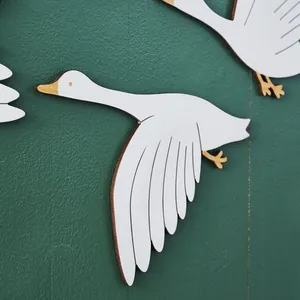 Detailaufnahme der Textur von weißen fliegenden Gänse-Wanddekorationen aus Holz auf Grün