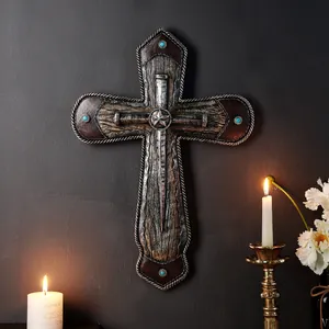 Cruz de pared gótica de resina con textura rústica en un cálido ambiente de velas.