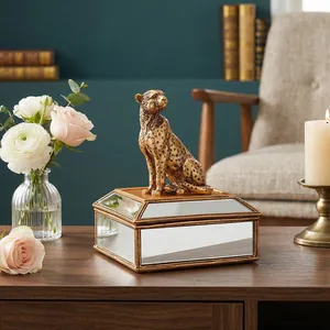 Élégante sculpture de léopard doré sur un coffret à bijoux miroir dans un décor chic.