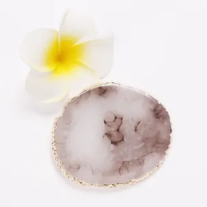 Close-up of gold-edged resin agate palette with grey marbled texture and flower
