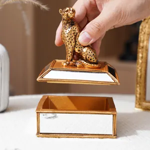 Détail du couvercle de guépard doré soulevé de la boîte à bijoux en miroir