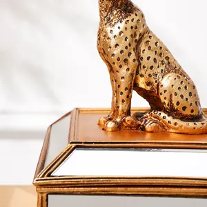 Détail de la figurine de guépard doré sur une boîte de rangement à bijoux miroir