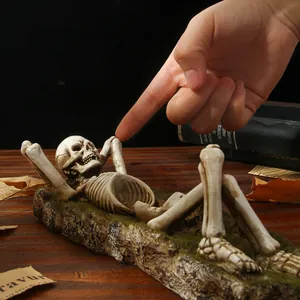 Detail view of a retro Gothic skeleton figurine lying on a mossy base ornament