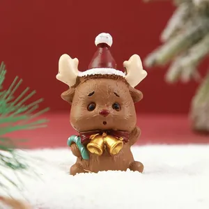 Detalle macro de una linda figurita de reno navideño con gorro de Papá Noel y campanas