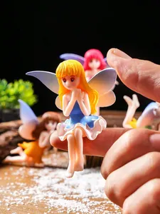 Close-up of a miniature yellow-haired fairy figurine sitting on a finger for garden decor