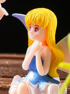 Macro close-up of a cute fairy garden figurine with wings and golden hair for micro landscape.