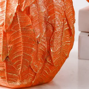 Gros plan sur la texture détaillée des feuilles et les nervures dorées d'un vase citrouille.