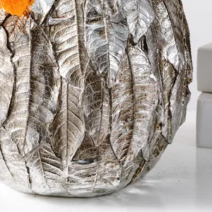 Gros plan sur la texture de feuille argentée d'un vase décoratif en forme de citrouille