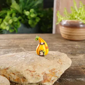 Vista detallada de una casa de calabaza miniatura en resina amarilla para micro-paisaje de jardín