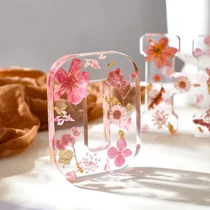 Dettaglio dell'ornamento in resina lettera O con fiori secchi rosa e scaglie d'oro