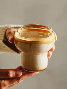Nahaufnahme eines einzigartigen hitzebeständigen Glases in Flaschenform mit Kaffee