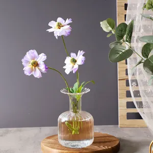 Elegant vertical stripe glass vase with purple artificial flower arrangement on wooden base.