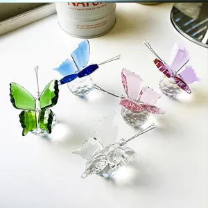 Primer plano de cinco figuritas de mariposa de cristal de colores sobre bases talladas