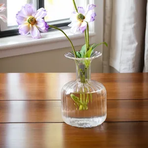 Detailed macro view of a ribbed transparent glass vase with fresh purple flowers