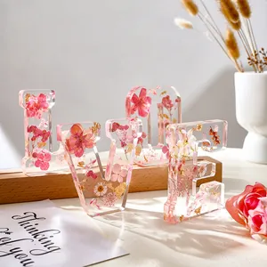 Primo piano dei dettagli delle lettere LOVE in resina con fiori secchi rosa e decorazioni