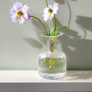 Detailed macro shot of an elegant ribbed transparent glass vase featuring purple poppies