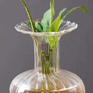 Close-up of transparent glass vase with vertical stripes and ripple edge detailing