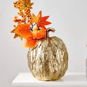 Vue rapprochée d'une citrouille dorée décorative avec texture de feuilles et feuillage d'automne