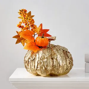 Vue détaillée d'un vase citrouille doré texturé avec feuilles d'automne