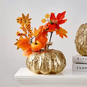Vase citrouille doré avec feuilles d'érable d'automne et décor de baies