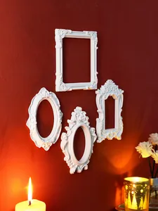 Elegant detail of four vintage white embossed wall frames on a textured red background