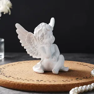 Detailed view of a white resin angel figurine sitting on a decorative cork mat for home decor
