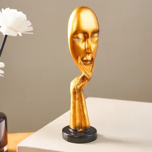 Detail of golden resin abstract mask sculpture Silence is Golden for artistic home interior decor