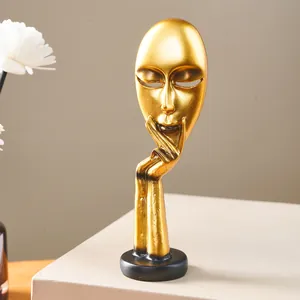 Detail view of a golden abstract face mask sculpture for modern Nordic home decor