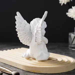 Detailed back view of a white resin angel figurine ornament on a wavy decorative tray
