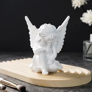 Detailed macro view of a minimalist white resin angel figurine sitting on a grooved tray