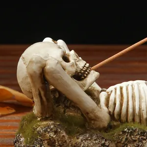 Vintage Gothic lying skeleton incense stick holder with realistic moss details on rocky base
