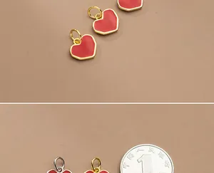 Detaillierte Nahaufnahme roter Emaille-Herzanhänger mit Gold- und Silberbeschichtung für DIY