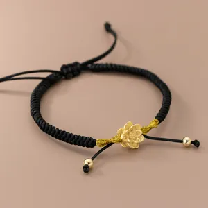 Bracelet en corde noire tissé à la main con breloque lotus en argent plaqué or et perles.