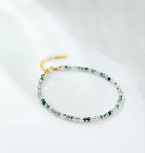 Close-up of natural green moss agate beads on a gold-plated adjustable bracelet
