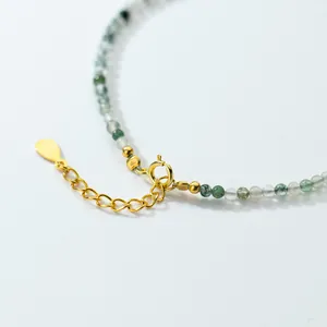 Detailed macro view of an adjustable moss agate bead bracelet with a gold plated clasp