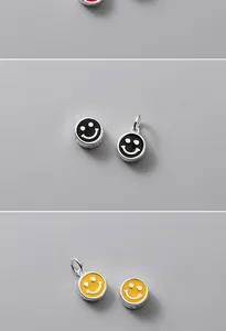 Macro view of S925 silver smiley face beads with black and yellow enamel details