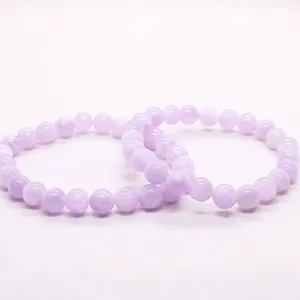 Macro view of two natural icy lavender purple quartz beaded bracelets on white background