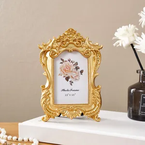 Detailaufnahme eines goldfarbenen Barock-Fotorahmens mit filigranen Blumenschnitzereien