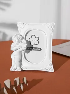 Close-up of a white vintage resin photo frame featuring a cherub angel playing a lyre