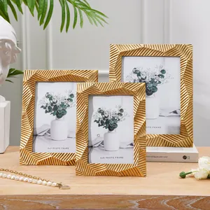Elegante Nahaufnahme von drei goldenen geometrischen Bilderrahmen mit Metallstruktur