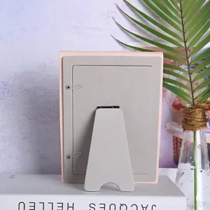 Detail showing the back of a 6-inch pink resin photo frame with a sturdy stand and clips