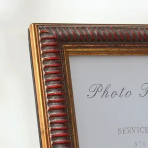 Detail view of American vintage distressed photo frame with gold and red finish