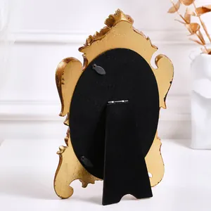 Rear view of vintage golden oval photo frame showing black velvet back and stand