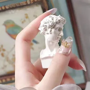 Detailed view of a mini David bust sculpture held between fingers for home decor
